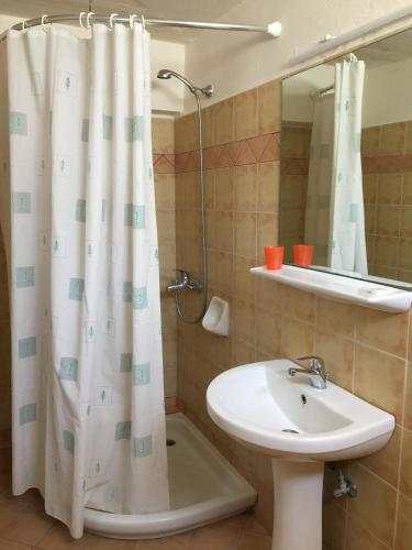a bathroom with a shower curtain and a sink at Galini Studios and Apartments in Lassi