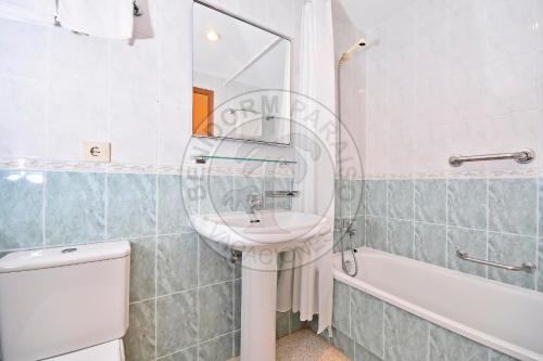 a bathroom with a sink and a mirror and a tub at Apartamentos Paraíso Centro - BenidormParaíso in Benidorm