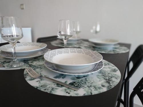 a table with plates and glasses on a table at Athani Summer House (Apartments 03 - 04) in Athani