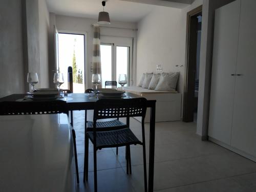 a black dining room table with chairs and a couch at Athani Summer House (Apartments 03 - 04) in Athanion