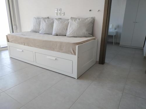 a white bed with pillows on it in a room at Athani Summer House (Apartments 03 - 04) in Athanion