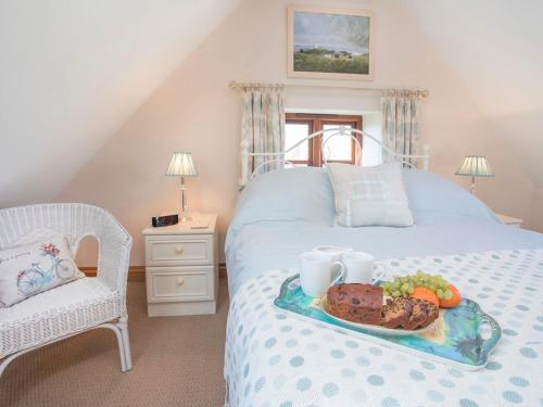 a tray of food on a bed in a bedroom at Hen Stabl Llandwrog in Llandwrog