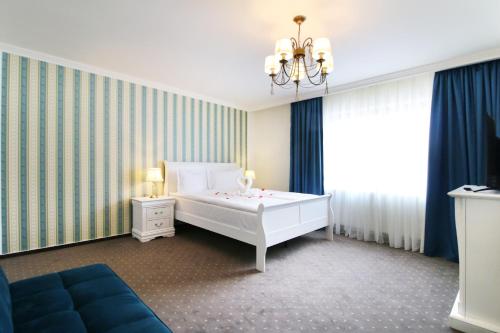a bedroom with a white bed and a blue couch at Select House in Sibiu