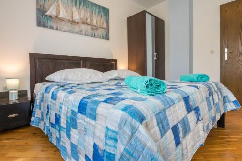 a blue and white bed with two towels on it at Apartman Vendi in Zagvozd