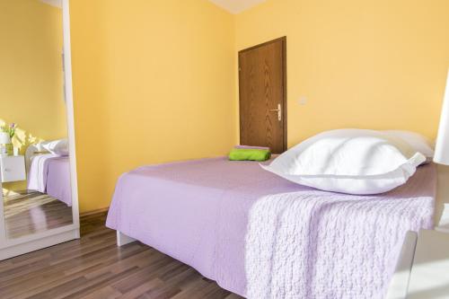 a bedroom with a white bed with a mirror at Apartman Vendi in Zagvozd