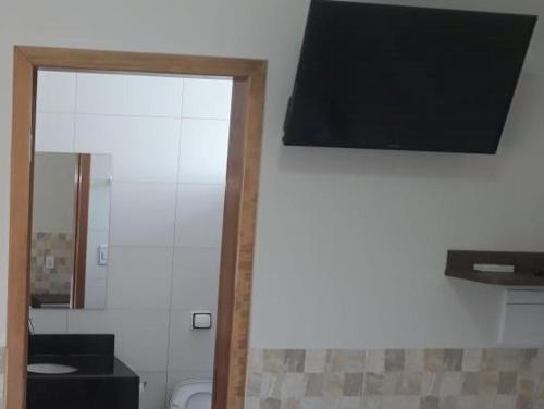 a bathroom with a toilet and a large mirror at Hotel Maringa in Maringá