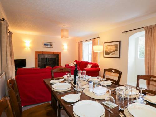 a dining room with a table and a red couch at Tigh Fasgaidh in Dornie