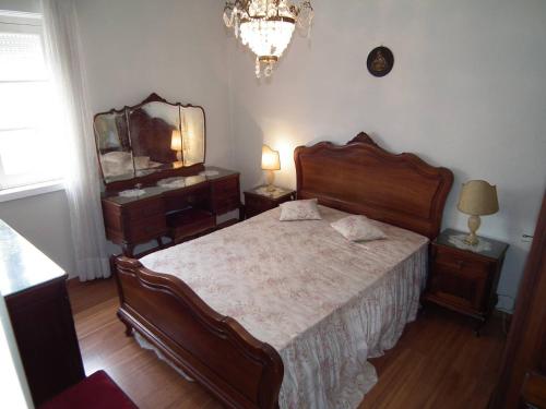 a bedroom with a bed and a dresser and a mirror at Casa Zizi Bela in Lourinhã
