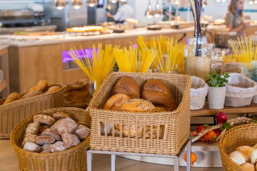 three baskets of bread on a table in a bakery at Leonardo Laura Beach & Splash Resort in Paphos City