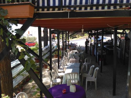 - un ensemble de tables et de chaises sur une terrasse dans l'établissement Zeytinada Pansiyon ve Gözleme, à Güney