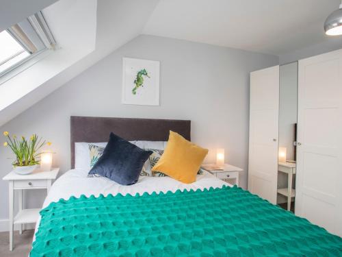 um quarto com uma cama grande com almofadas azuis e amarelas em Isallt em Trearddur