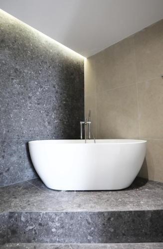 a white bath tub sitting on a counter in a bathroom at Deliades Hotel in Ornos