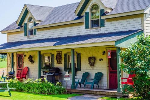 a house with colorful chairs on the front porch at Bugaboo Cottages in Summerside