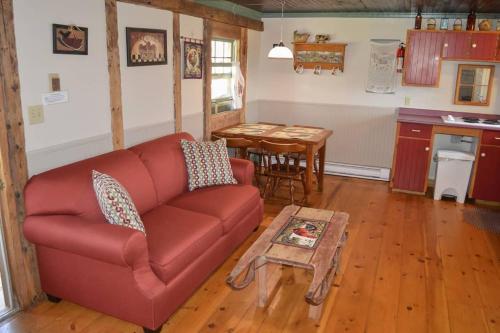 a living room with a red couch and a table at Bugaboo Cottages in Summerside
