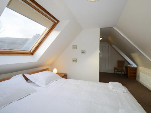a bedroom with a bed with a large window at Tigh Fasgaidh in Dornie
