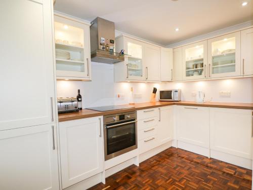 a white kitchen with white cabinets and appliances at Tigh Fasgaidh in Dornie