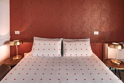 a bedroom with a bed with red walls and two lamps at Alla Riva in Verona