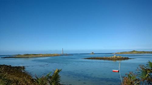 an island in the water with a boat in it at Maison Molène, au Pays des Abers Plouguerneau in Plouguerneau