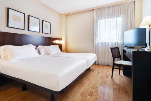 um quarto de hotel com uma cama, uma secretária e um computador em Hotel Sercotel Tudela Bardenas em Tudela