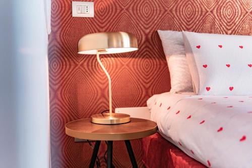a lamp on a table next to a bed at Alla Riva in Verona