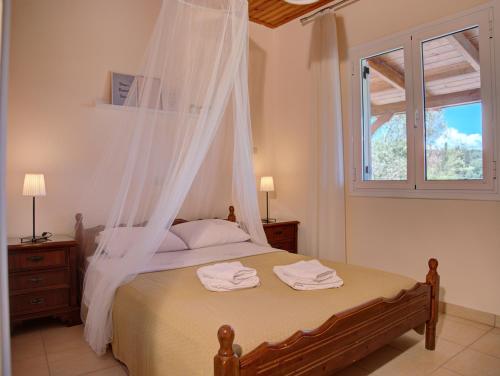 a bedroom with a bed with a mosquito net at Guesthouse Agia Triada in Koroni