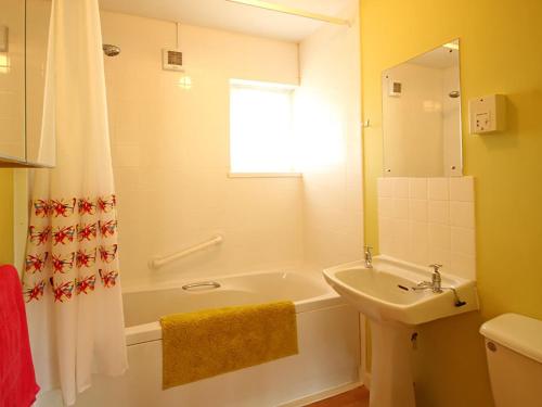 a bathroom with a tub and a sink and a shower at Mor Edrin in Criccieth