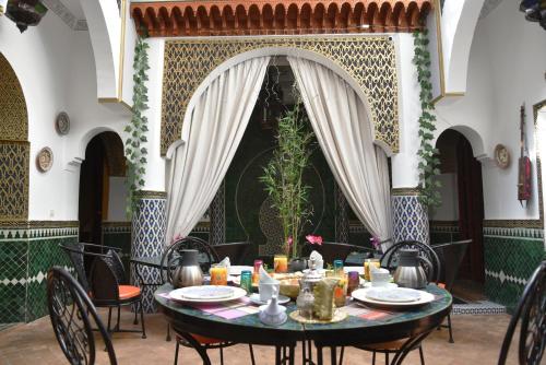 a dining room with a table and chairs at Riad Assalam in Marrakech