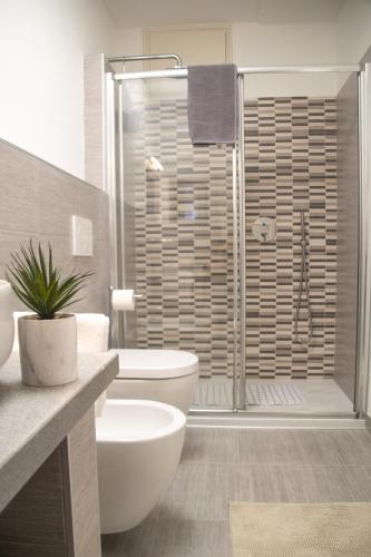 a bathroom with a toilet and a glass shower at Casa Brunetta - WelcHome in Stresa