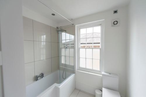 ノリッジにあるSt Stephens Road Apartmentの白いバスルーム(シャワー、窓付)が備わります。