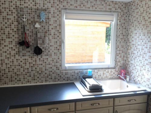 eine Küche mit einem Waschbecken und einem Fenster in der Unterkunft Ferienhaus Am Lutherweg in Seeburg