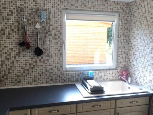 una cucina con un lavandino e una finestra di Ferienhaus Am Lutherweg a Seeburg