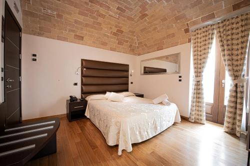 a bedroom with a large bed and a brick wall at Antico Borgo Chieti in Chieti