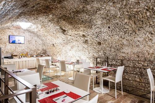 un comedor con mesas blancas y sillas blancas en Antico Borgo Chieti, en Chieti