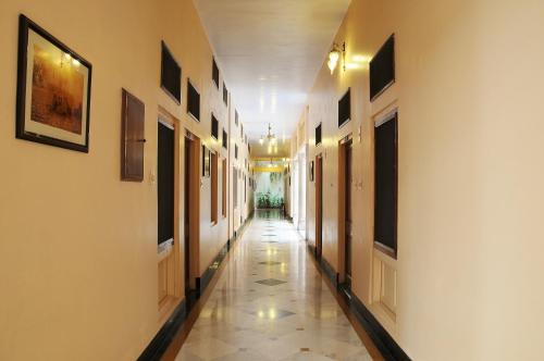 an empty hallway with white walls and a tile floor at Hotel Arya Niwas in Jaipur