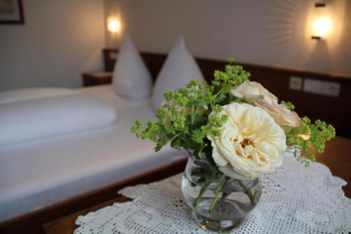 a vase with flowers on a table in a bedroom at Haus Schnetzer in Schruns-Tschagguns