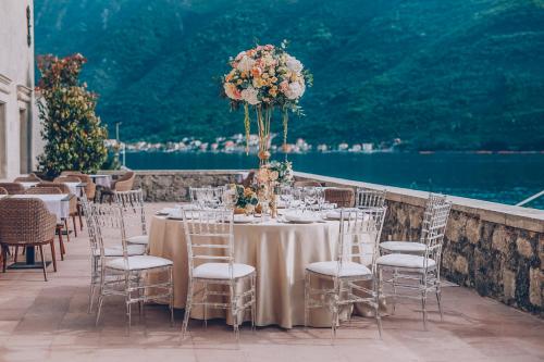 a table set up for a wedding with chairs and flowers at Heritage Grand Perast By Rixos in Perast