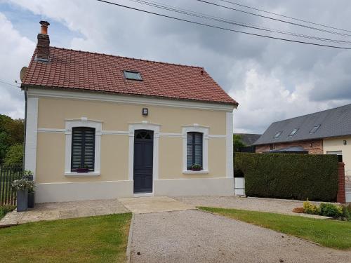 una pequeña casa amarilla con techo rojo en Le Gîte d'en Bas, en Quesnoy-le-Montant