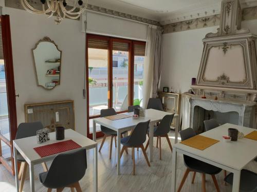 una sala da pranzo con tavoli, sedie e camino di La Dimora del Conte a Pescara