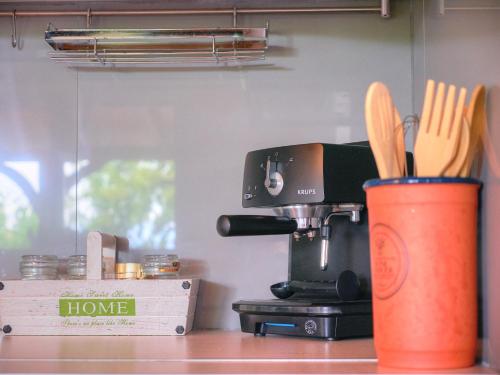 a kitchen counter with a coffee maker and a cup with utensils at Guesthouse Agia Triada in Koroni