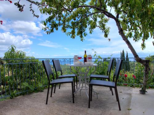 a table with chairs and a bottle of wine at Guesthouse Agia Triada in Koroni