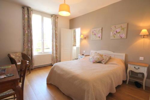 a bedroom with a bed and a desk and a window at LES CHAMPS RABATS in Villers-sur-Mer