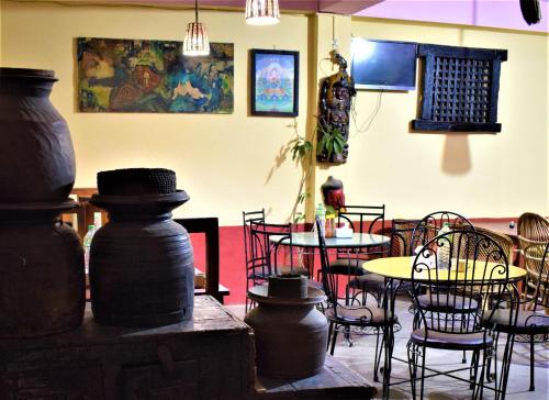 ein Esszimmer mit Tischen, Stühlen und Töpfen in der Unterkunft Berg House Cafe and Hotel in Nagarkot