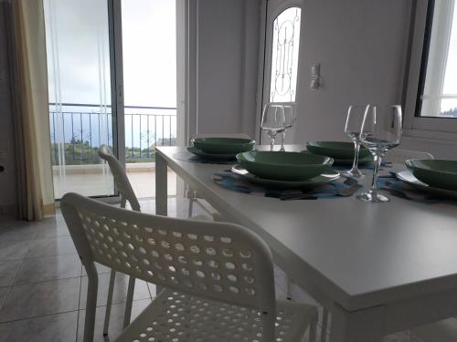 a dining room table with green plates and wine glasses at Athani Summer House (Apartments 01 - 02) in Athanion