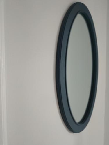 a black mirror hanging on a white wall at Athani Summer House (Apartments 01 - 02) in Athanion