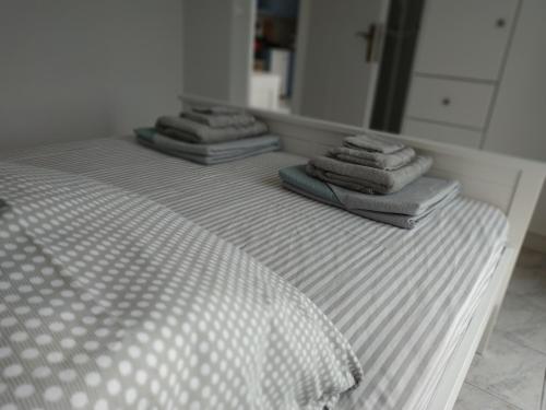 three stacks of towels sitting on top of a bed at Athani Summer House (Apartments 01 - 02) in Athanion