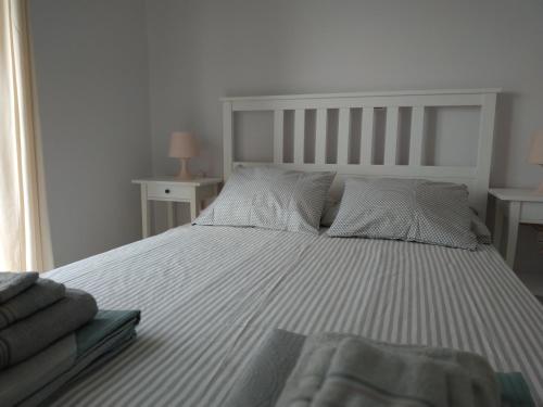 a bedroom with a large bed with striped sheets and pillows at Athani Summer House (Apartments 01 - 02) in Athanion