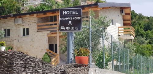 a hotel sign in front of a building at Hotel Grandpa's House in Shkodër