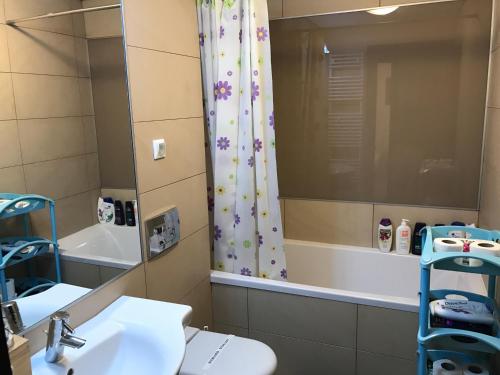 a bathroom with a shower curtain and a sink at Upground Apartment 2019 in Bucharest