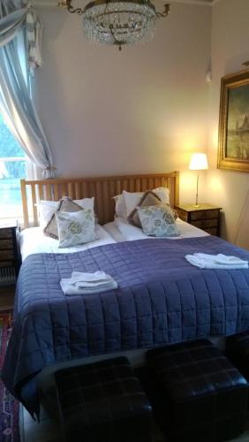 a bedroom with a blue bed with towels on it at Kolbäcks Gästgivaregård in Kolbäck