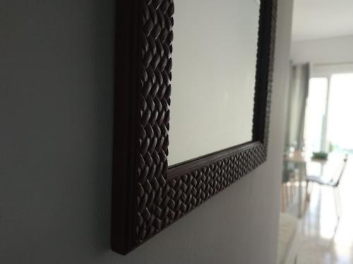 a mirror with a black frame on a wall at Athani Summer House (Apartments 01 - 02) in Athanion
